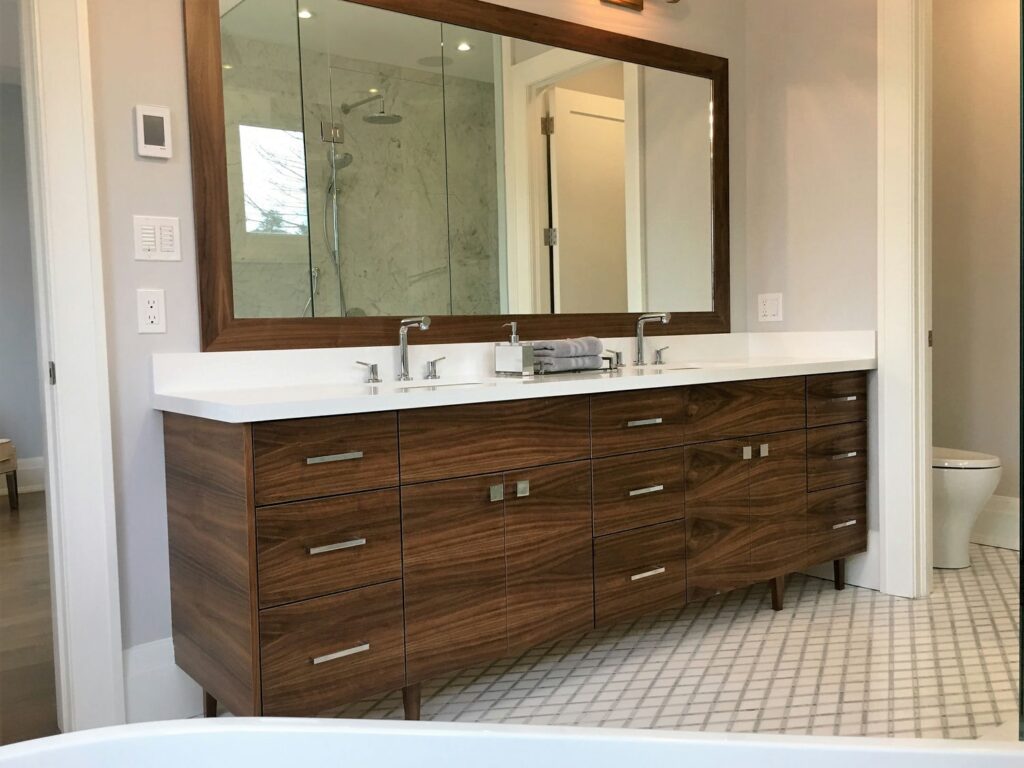 American black walnut double vanity on tapered legs with a white quartz top and matching walnut-framed mirror